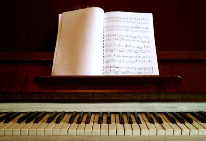 Unfamiliar sheet music open on a piano stand