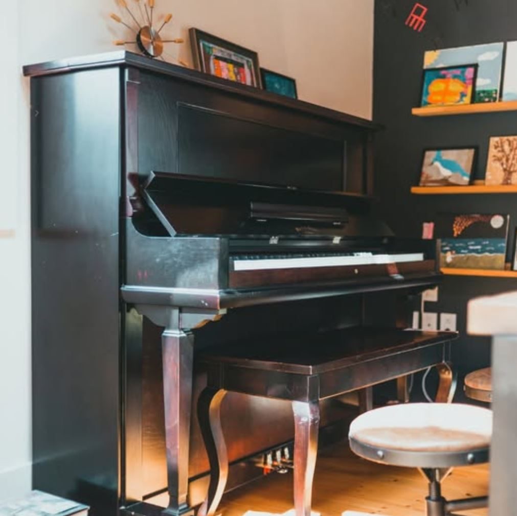 Upright piano in a living room away from windows and radiators